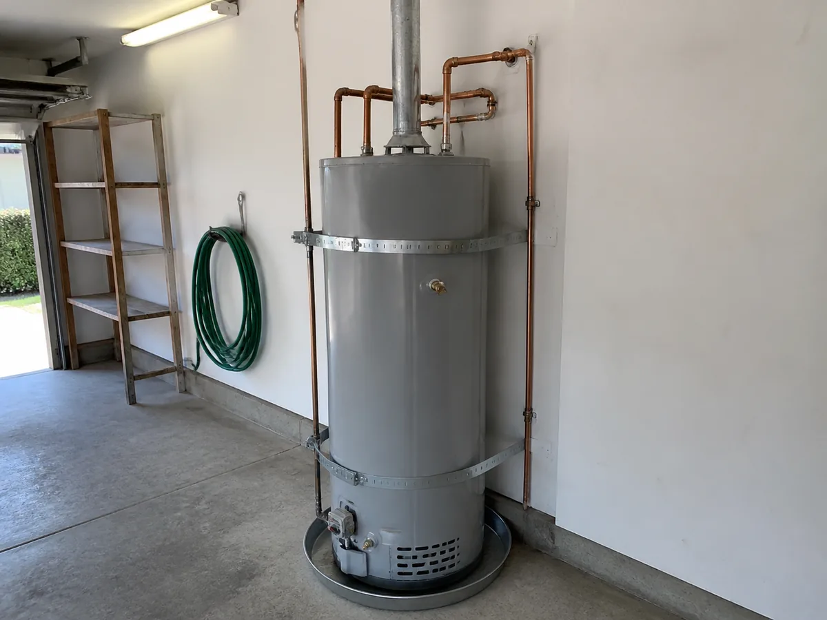 A newly installed water heater with copper lines and a drip pan