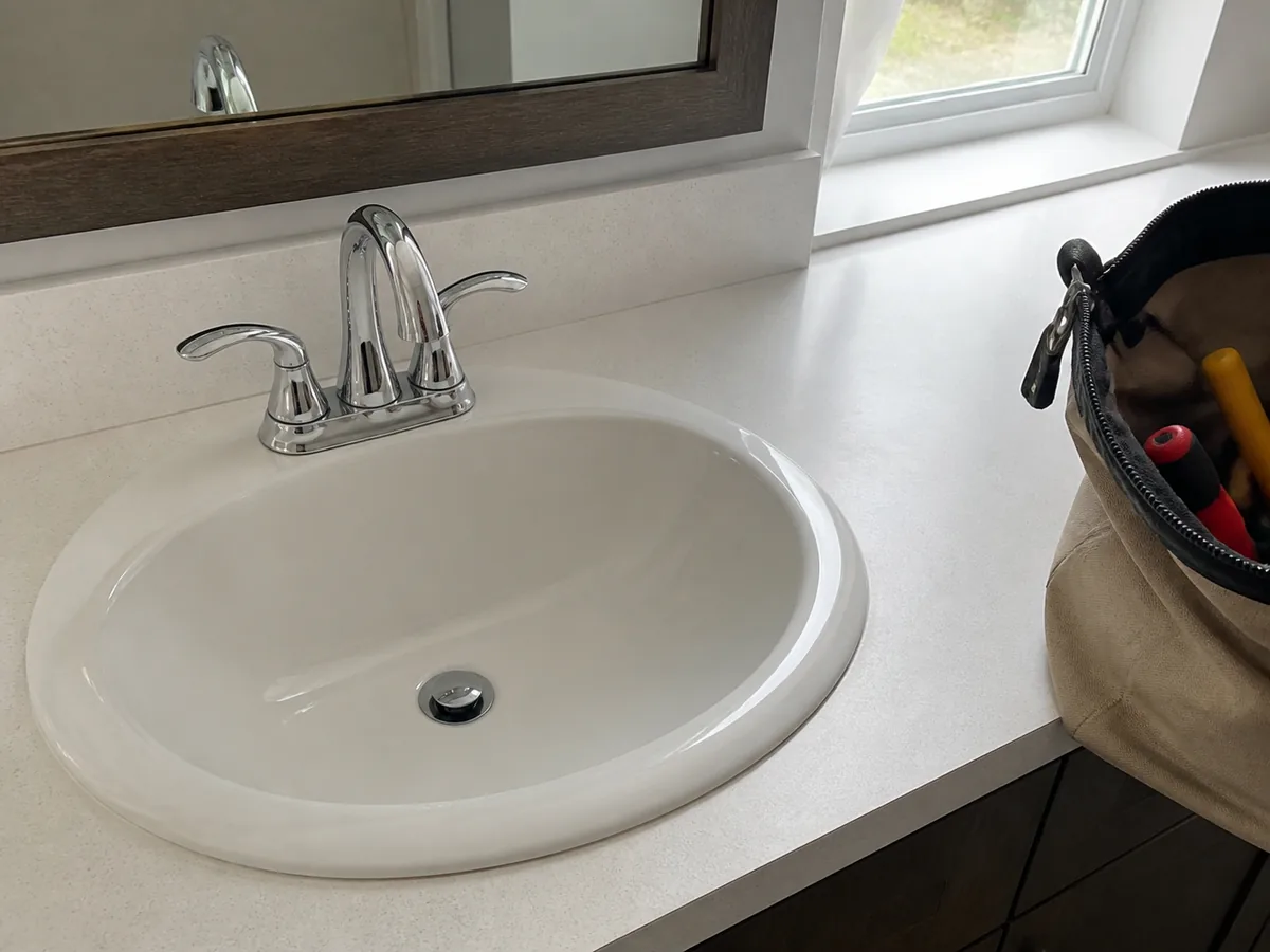 A finished bathroom faucet, wiped down, tools packed away